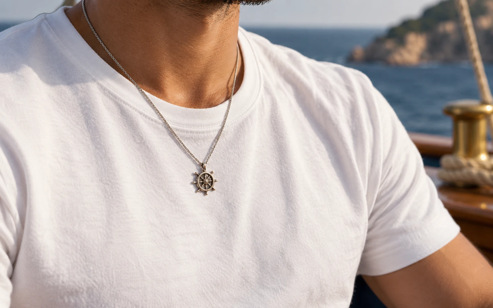 Collier à pendentif gouvernail porté sur un T-shirt blanc uni