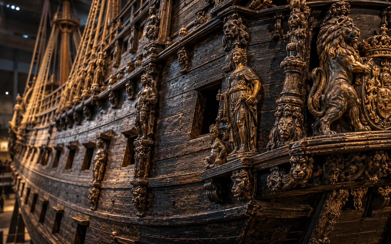 Détail d’une coque en chêne de navire ancien avec des sculptures sombres et dorées, lumière de musée